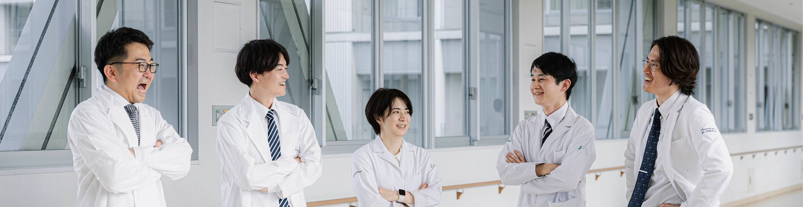 廊下で談笑する白衣の医師たち