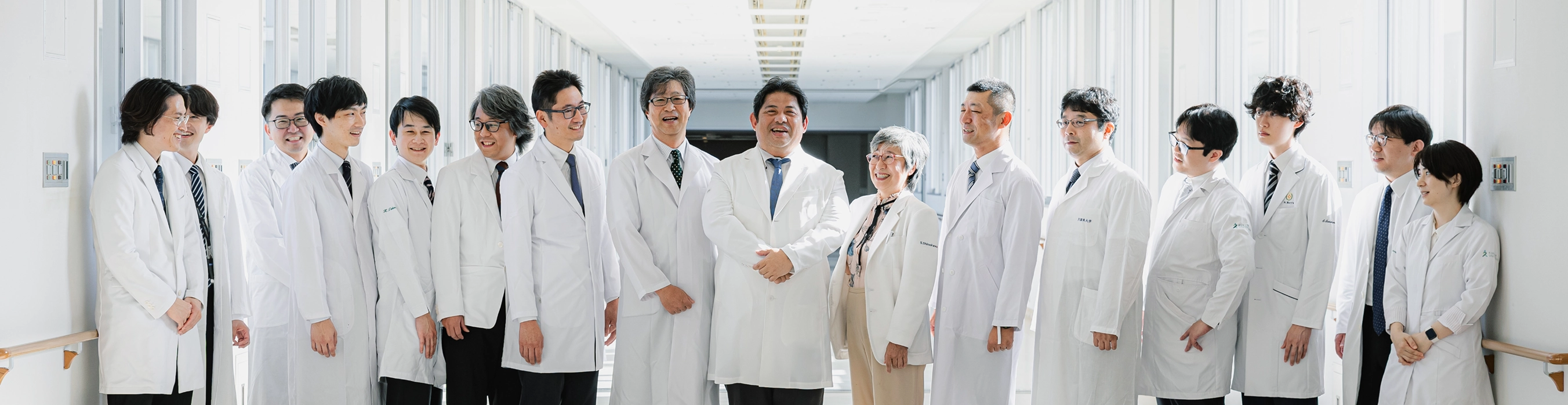 明るい廊下に並ぶ白衣のスタッフ