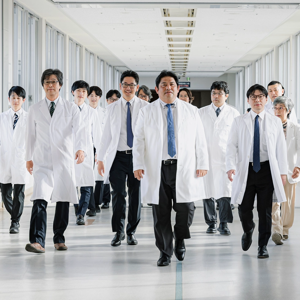 白衣の医師たちが明るい廊下を歩いてくる様子