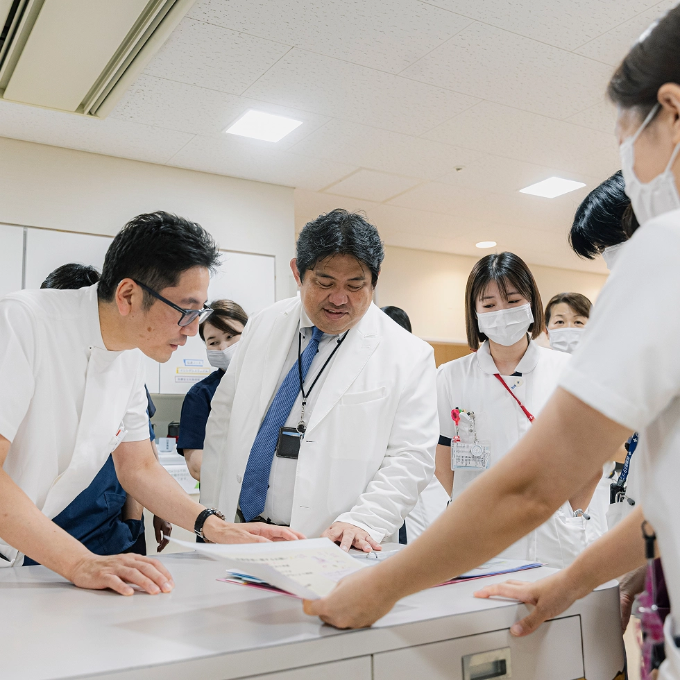 モニターを確認する女性医師と周囲の医師たち