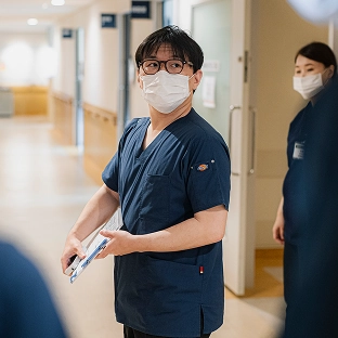 スクラブ姿の女性スタッフが前方を見つめる様子